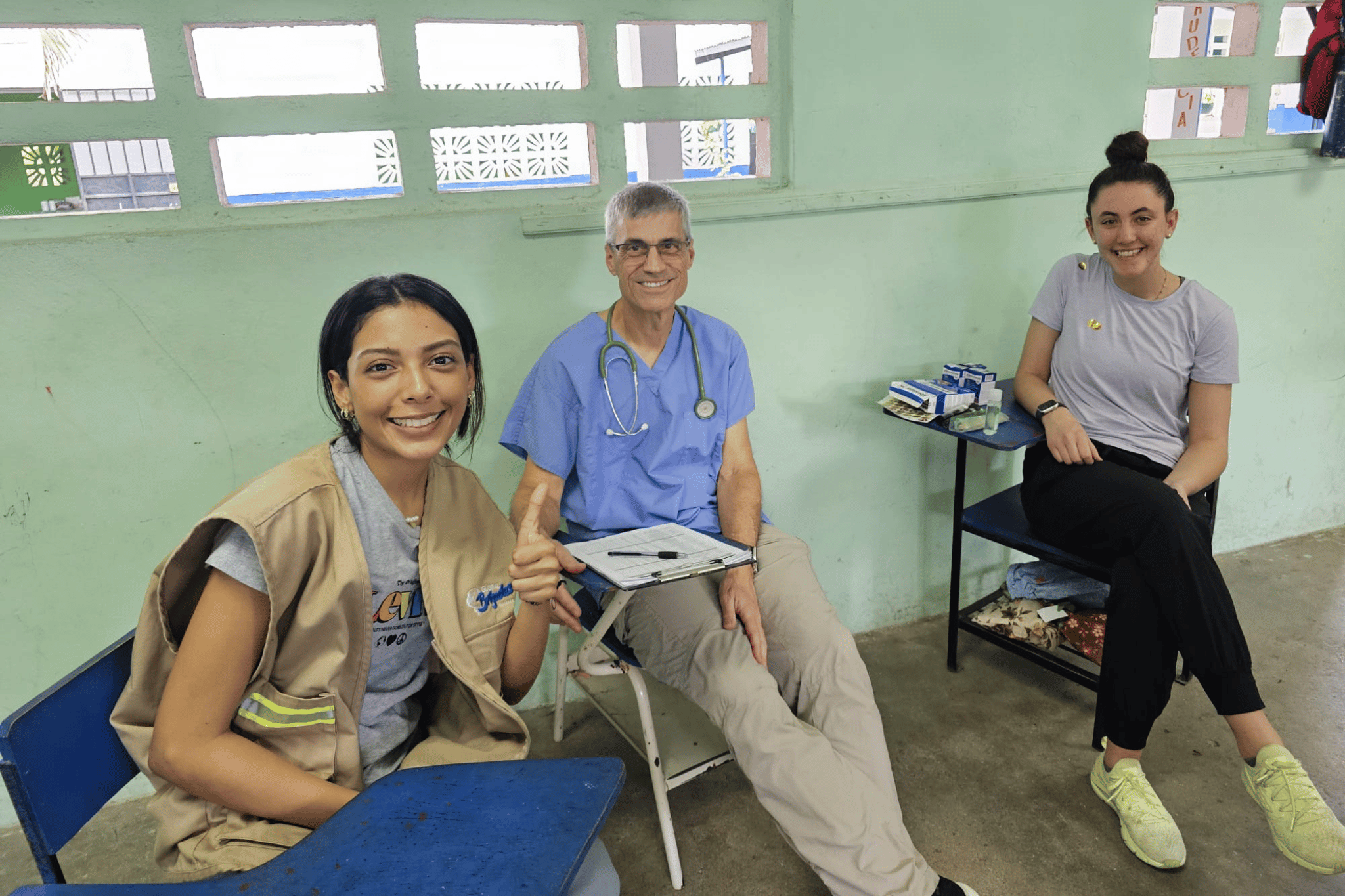 two students on a medical brigade with a local physician at the in-country clinic